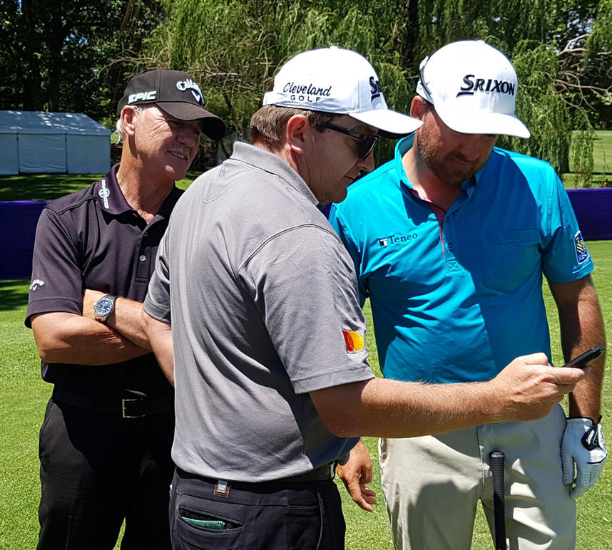 Caddy Ken Comboy shows McDowell and coach, Pete Cowen the video he took of Cowen in the rough at Erin Hills